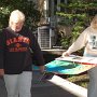 Volunteers Judy Kaiser and Deborah Crim move a display.