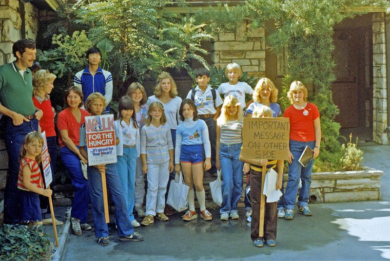 1981.jpg - The Stone Church Youth Group assembles at church before joining others for the Fall, 1981 CROP Walk.  (The sign on the right had the same message on both sides - it got attention and several laughs!)
