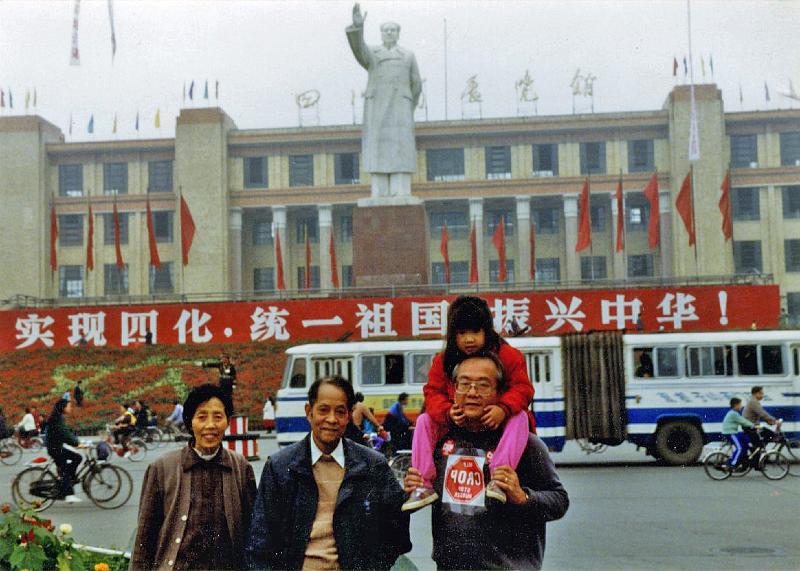 1989-1.jpg - Stone Church member Gene Wei (on right) was in Beijing, China in the Fall of 1989, so organized a small Crop Walk there.  Here he is outside the Peoples Government Building.  He noted that the "statue is one of the very few still standing in China today.  Hopefully this will soon be gone."  (L-R) Aunt Jun Zhong, Uncle Hua Tao, and Gene with Isabel riding on his shoulders.