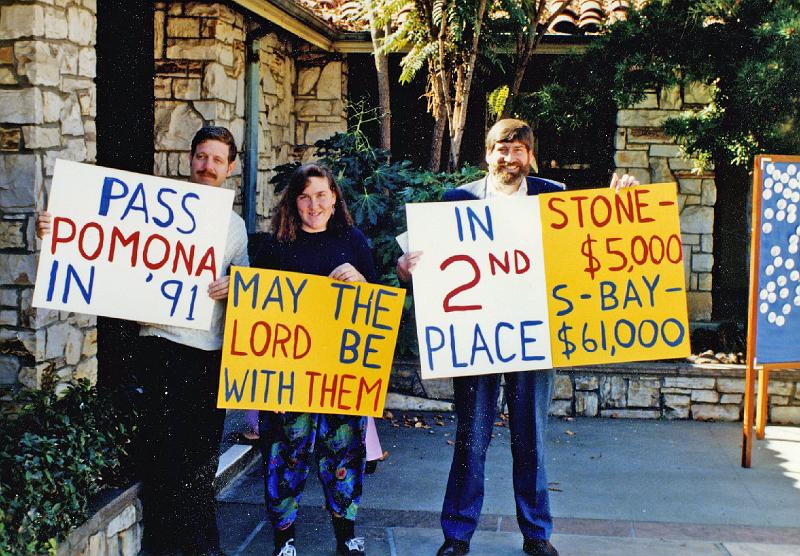 1991.jpg - Competition is on between the Pomona, CA CROP Walk (west coast's largest) and the local South Bay Walk, who wishes to replace them.  Stone Church members Derk Johnson, Karen Hagan and Jim Hagan are here with signs expressing that sentiment.  (1991)
