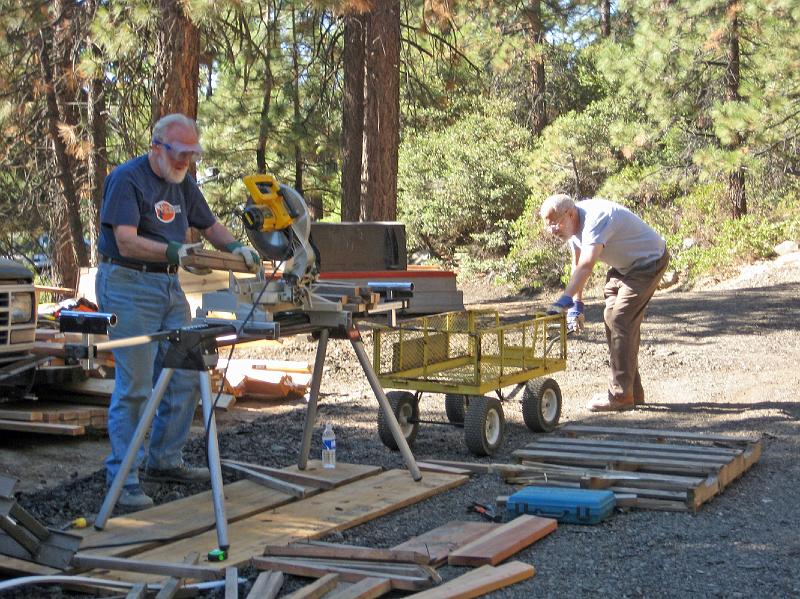 212.jpg - Meanwhile, back on the ground, Rod Thorn and Bill Lakatos saw much scrap lumber into firewood-sized pieces, for winter cabin residents to use.