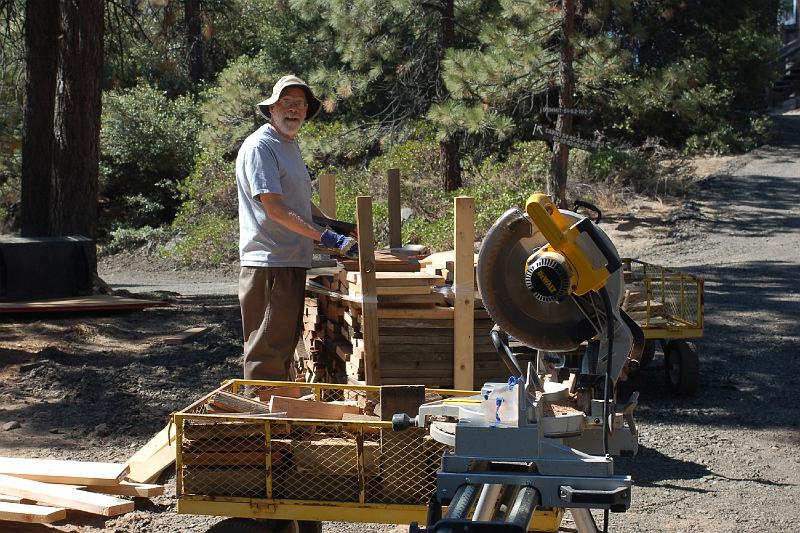 314.jpg - Bill Lakatos surveys a rapidly growing cache of firewood for cabin residents.
