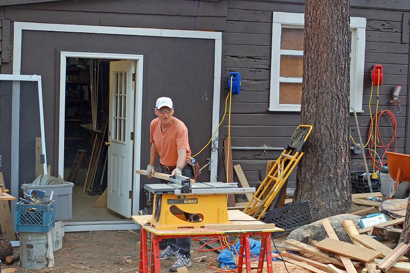 DSC_0008.JPG - A hundred yards away, near the office building, John cuts pieces for the railing sections.