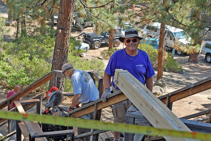 DSC_0045.JPG - Stephen (R) takes a break from carrying lumber to the work site, while Bill saws scrap wood.