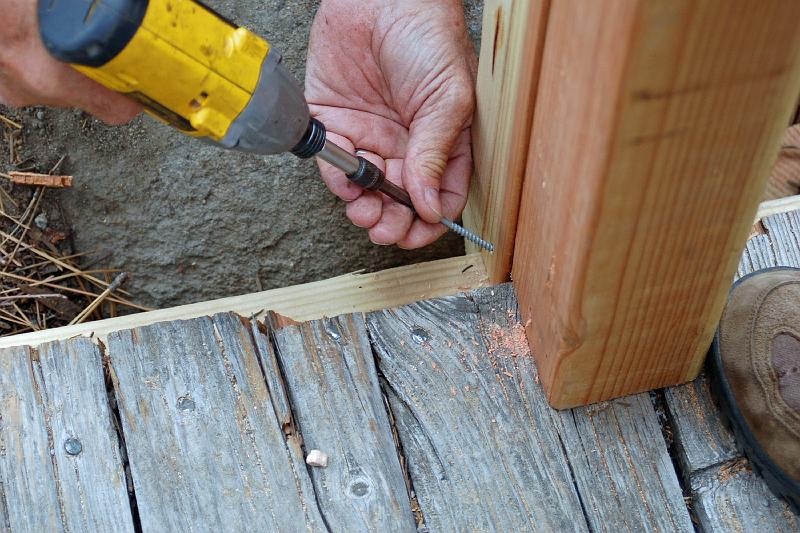 DSC_0132.jpg - The post is toenailed into place.  Note the boulder just behind the drill and hand.